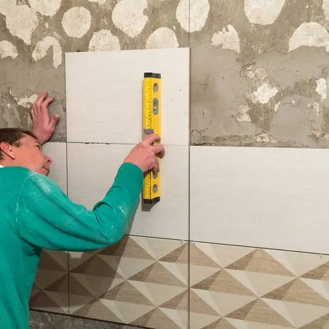 Posa di un rivestimento a parete con livella